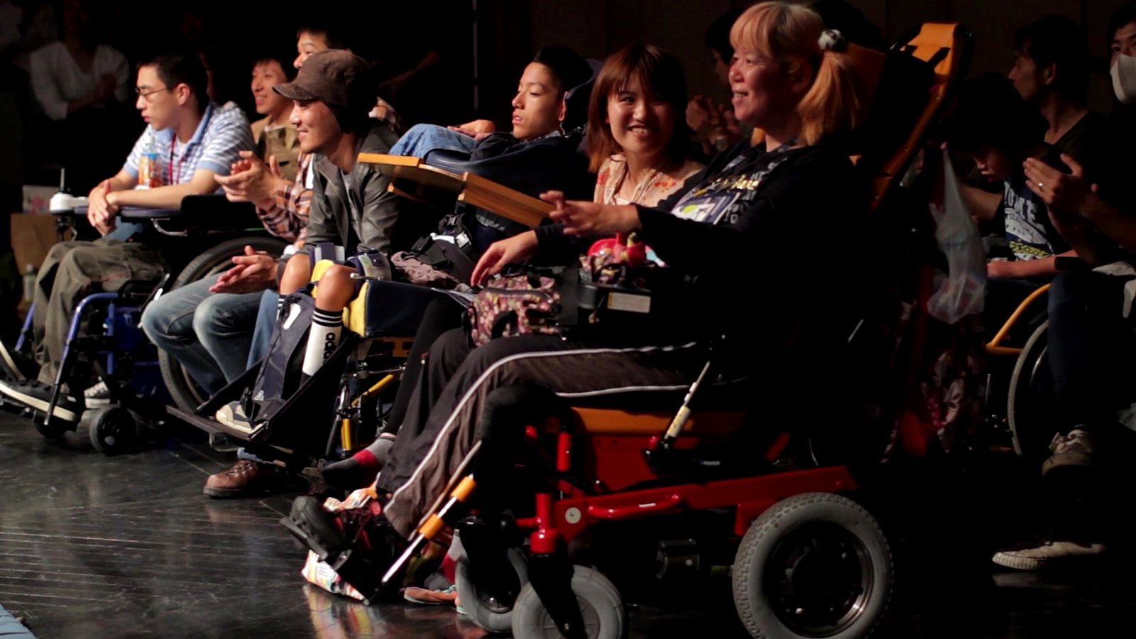 The crowd at ringside at a Doglegs show, many in wheelchairs, laughing
