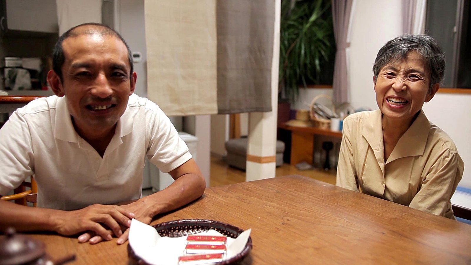 Shintaro and his mother laughing at the kitchen table